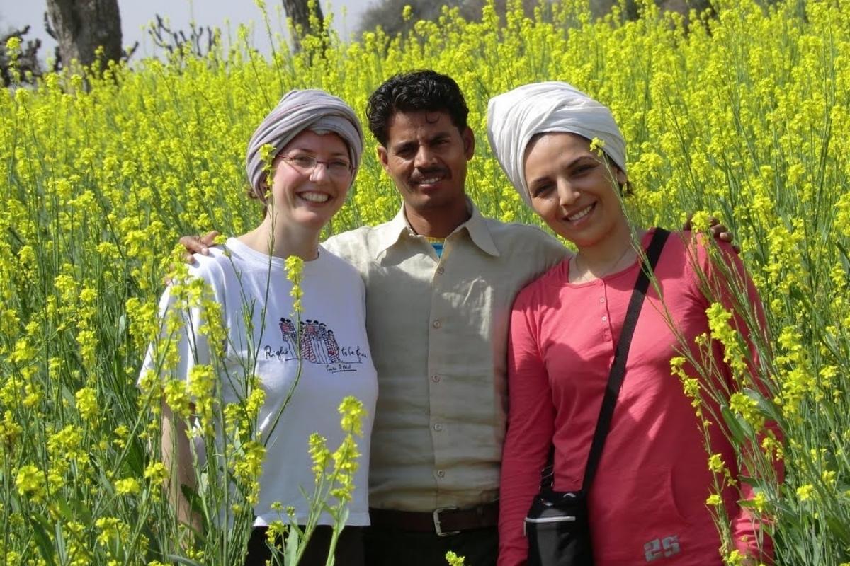 Voyageuses en Inde avec leur guide au milieu des champs