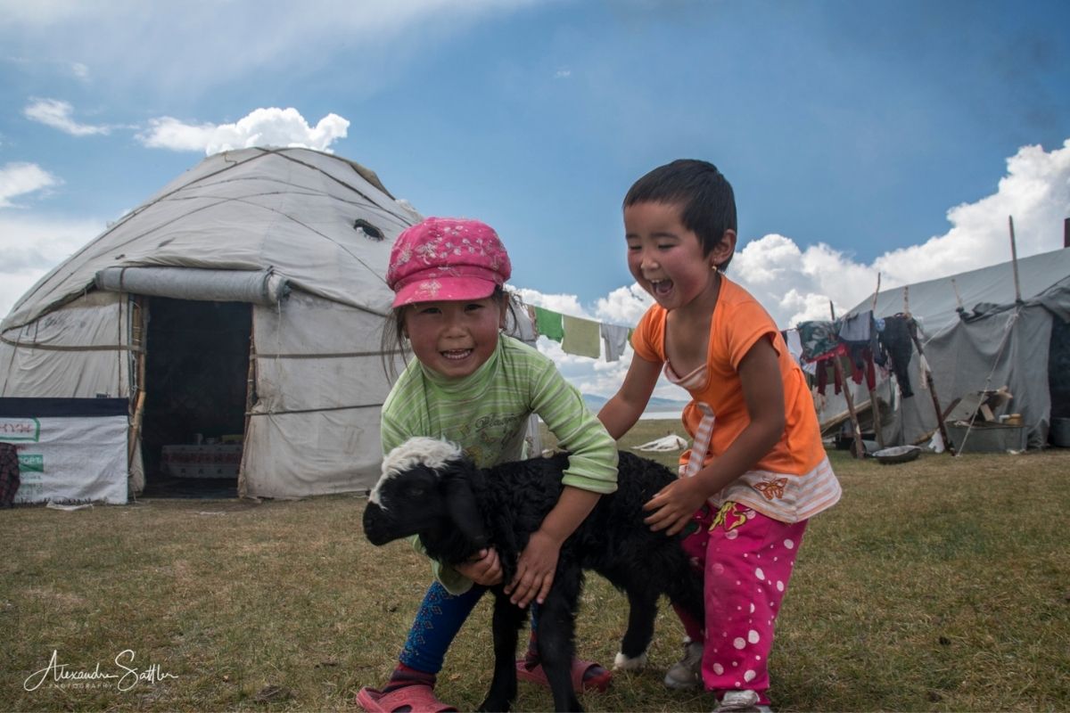 Petites filles kirghizes joyeuses devant leurs yourtes au lac Son-Kul, Kirghizistan