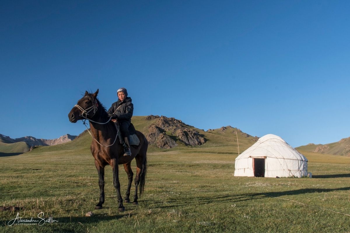 jeune homme kirghize à cheval devant sa yourte 