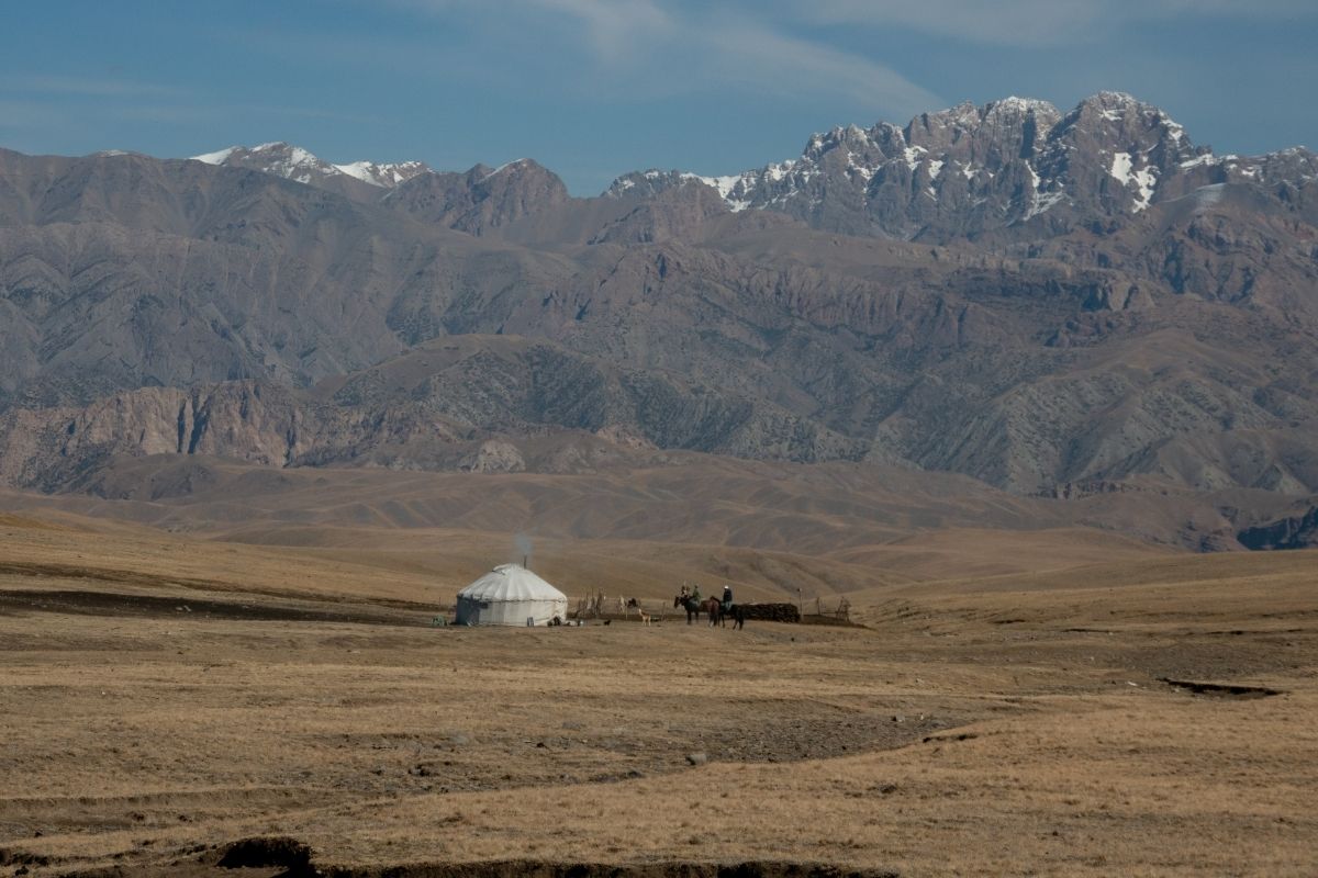 Yourte et chevaux sur fond de montagnes Kirghizistan