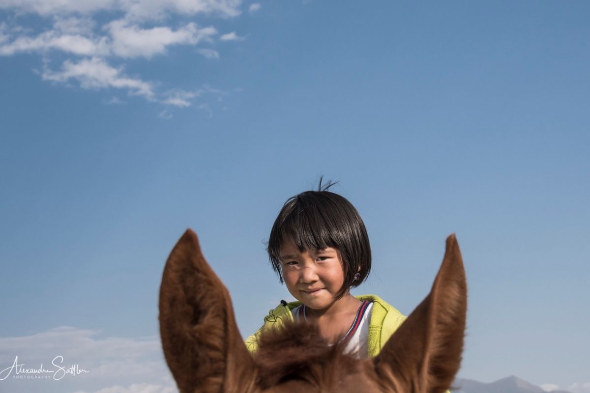 Petite fille kirghizistan sur un cheval - culture nomade kirghizistan